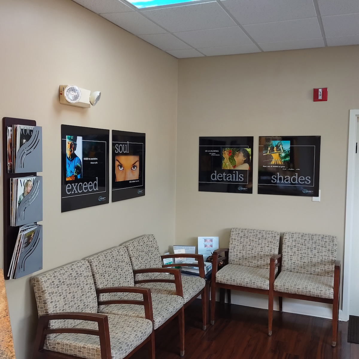 The image shows an interior office space with framed prints on the wall above a desk, featuring text and images related to dental care or services.