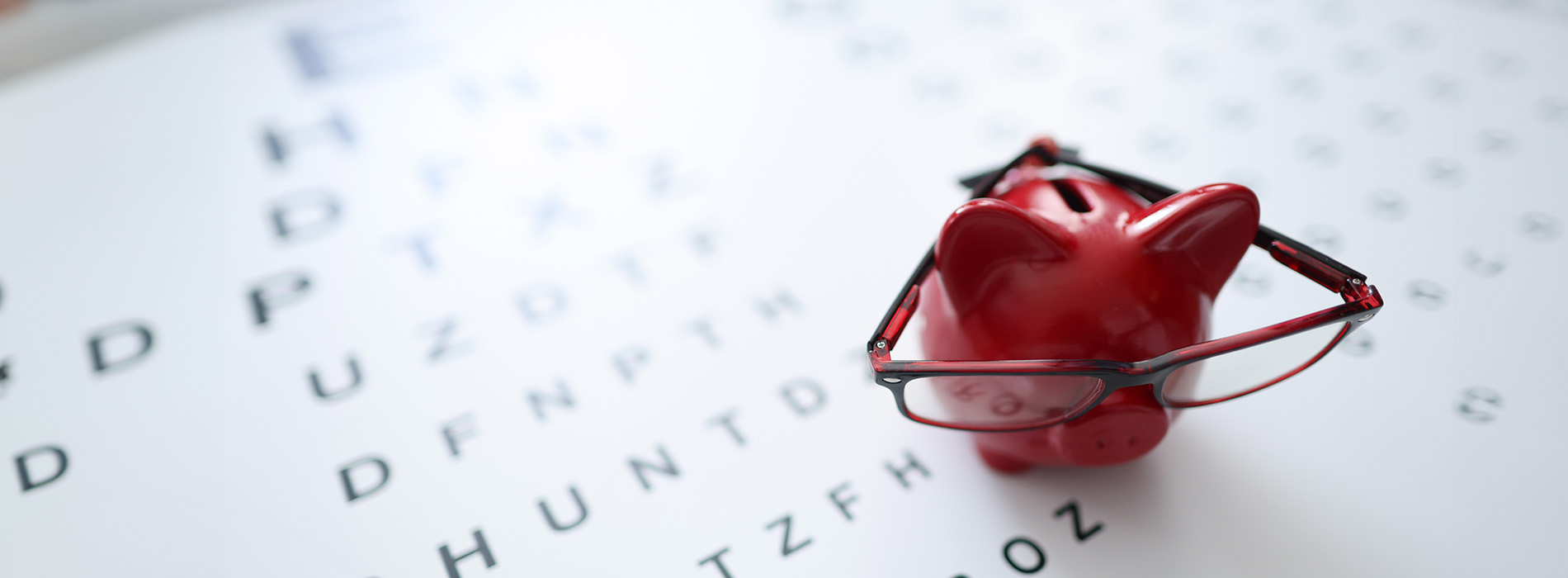 The image displays a red mechanical pencil on top of a white crossword puzzle page with letters and numbers visible, set against a light background.