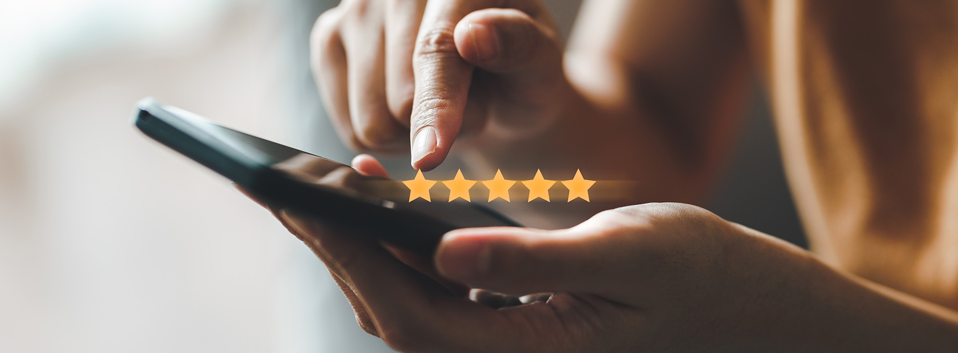 The image shows a person s hand holding a smartphone with a social media interface displaying a star rating icon, suggesting an app or platform where users can rate content or services.