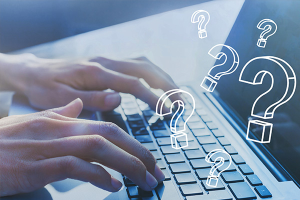A person s hands typing on a laptop keyboard with question marks floating around, suggesting a theme of questions or problem-solving.