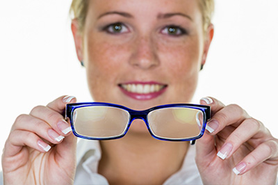 A woman wearing blue glasses with her eyes closed, holding them up to her face.